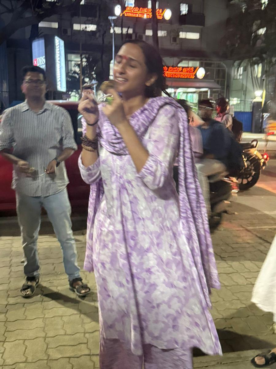 A young woman singing on the street during the evening kirtan