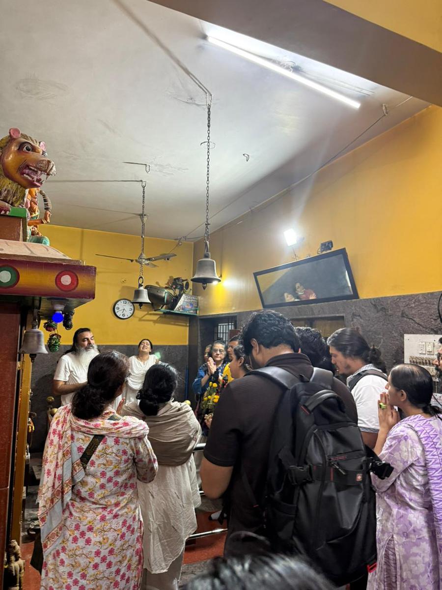Inside a local temple, a crowd of walkers and devotees gathered for kirtan after a walk